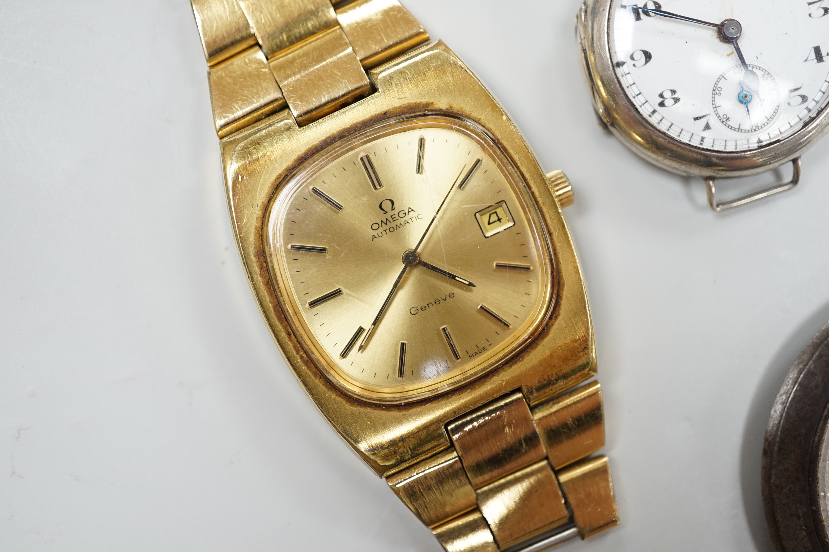A George V silver pocket watch with arabic dial, 3.25cm, a gentleman's gold plated Omega Automatic wrist watch with loose bracelet, a gun metal dress watch and a Surena gold overlaid cocktail watch